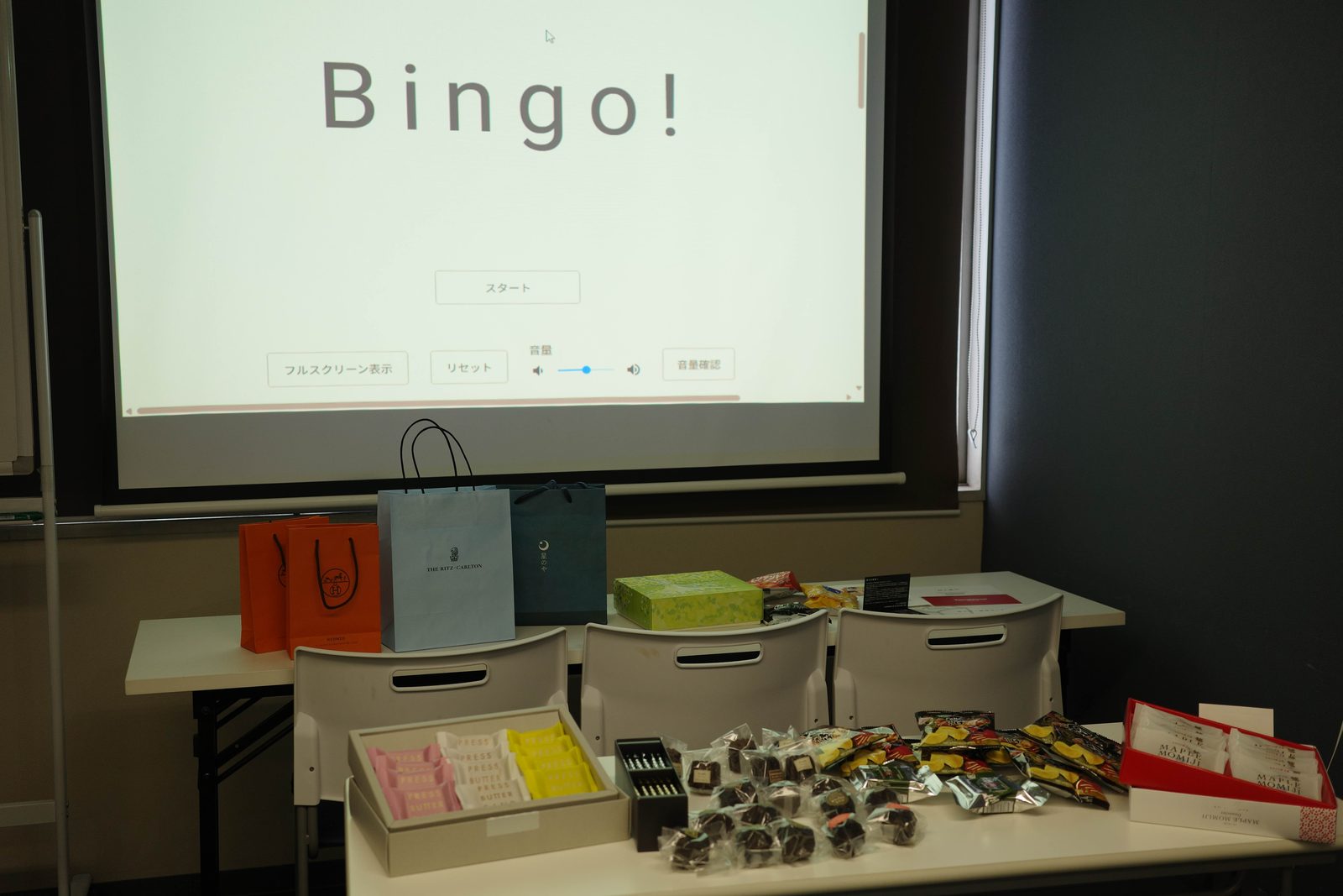 大阪オフ会のビンゴ大会。スクリーンと景品が並ぶ会場
