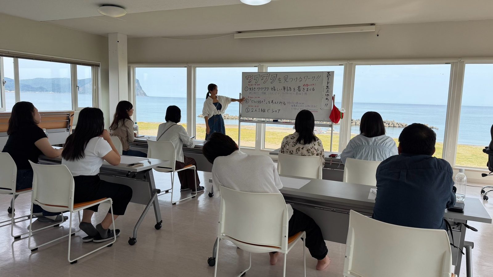 余市での研修の様子。海の見える会場で講師の話を聞く受講生たち